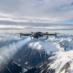 Quels drones d’ensemencement choisir face à Rainmaker pour faire pleuvoir ? Drone VTOL d’ensemencement survolant des montagnes enneigées sous des nuages froids, avec une visualisation discrète de données météorologiques abstraites.